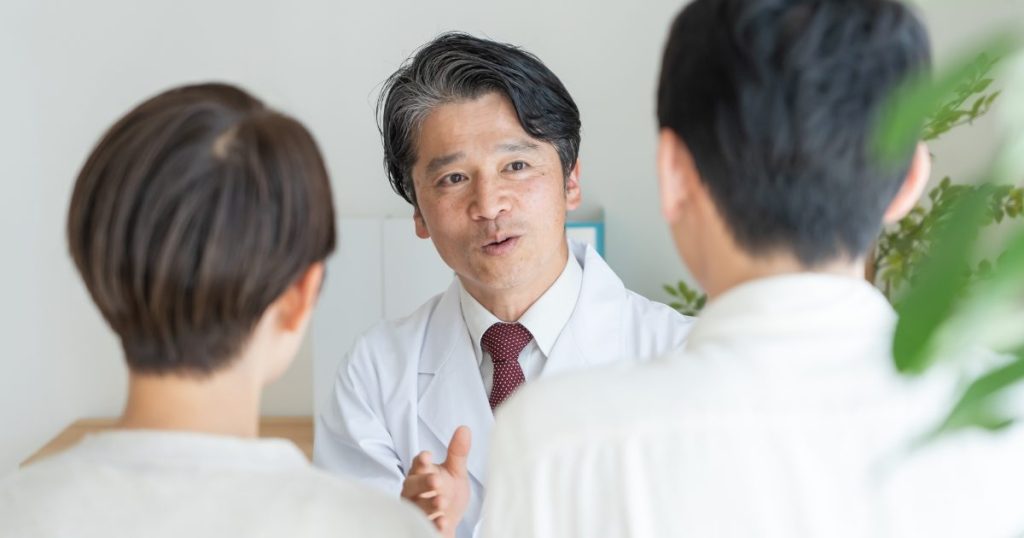 夫婦の相談に丁寧に応える医者